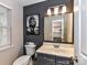 Stylish half bathroom with a gray accent wall, modern vanity, and decorative mirror and lion artwork at 9530 Elizabeth Townes Ln, Charlotte, NC 28277