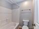 Bright bathroom featuring a white tiled shower-tub combo and a modern toilet at 9530 Elizabeth Townes Ln, Charlotte, NC 28277