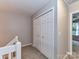 Upstairs hallway featuring double door closet, neutral wall color, and carpet flooring at 9530 Elizabeth Townes Ln, Charlotte, NC 28277