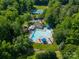 Aerial view showcasing the community pool, clubhouse, playground, and surrounding lush green landscaping at 9920 White Cascade Dr, Charlotte, NC 28269