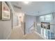 Bright upstairs hallway with staircase and multiple doorways to bedrooms at 9920 White Cascade Dr, Charlotte, NC 28269