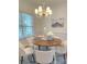 Bright dining area with a round wooden table, chandelier, and a picturesque window view at 1006 Phar Lap Dr, Indian Trail, NC 28079