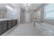 Bright bathroom features double vanity, chandelier, walk-in shower, and soaking tub at 1048 Harbor Bay Dr, Indian Land, SC 29707