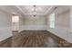Spacious dining room with hardwood floors, wainscoting, tray ceilings, and modern chandelier at 1048 Harbor Bay Dr, Indian Land, SC 29707