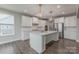 Bright, open kitchen boasts white cabinets, a large island, and stainless steel appliances at 1048 Harbor Bay Dr, Indian Land, SC 29707