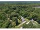 Aerial view of a home nestled among dense trees, featuring a large lot, a detached garage, and proximity to a wooded area at 10501 Mount Olive Dr # 7, Mount Pleasant, NC 28124