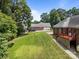An expansive green backyard features a red brick house, a red deck, and a detached garage, all surrounded by mature trees at 10501 Mount Olive Dr # 7, Mount Pleasant, NC 28124