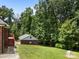 Lush green backyard with a brick house, wooden deck and surrounded by mature trees at 10501 Mount Olive Dr # 7, Mount Pleasant, NC 28124