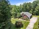 Well-manicured front yard with lush green lawn and mature landscaping leading to a charming red brick home with an attached garage at 10501 Mount Olive Dr # 7, Mount Pleasant, NC 28124