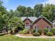 Well-maintained brick home with a curved walkway, manicured shrubs, and mature trees, showcasing charm at 10501 Mount Olive Dr # 7, Mount Pleasant, NC 28124