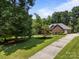 Manicured front yard with a brick house, mature trees, and a long driveway at 10501 Mount Olive Dr # 7, Mount Pleasant, NC 28124