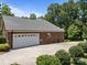 Side view of a brick home with an attached garage and a wide concrete driveway at 10501 Mount Olive Dr # 7, Mount Pleasant, NC 28124