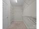 Spacious walk-in closet with metal shelving and neutral carpet and paint at 10501 Mount Olive Dr # 7, Mount Pleasant, NC 28124