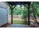 View of the backyard from beneath a covered porch, surrounded by trees and a wooden fence at 10548 English Setter Way, Charlotte, NC 28269