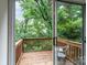 View of wooden deck overlooking green trees and foliage, accessed by sliding glass doors at 10548 English Setter Way, Charlotte, NC 28269