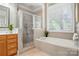 Bathroom featuring a soaking tub, separate shower, and a large window with natural light at 10607 Newberry Park Ln, Charlotte, NC 28277