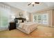Serene main bedroom featuring plush carpet, tray ceiling, and large windows that brings in natural light at 10607 Newberry Park Ln, Charlotte, NC 28277