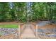 Charming wooden bridge surrounded by lush greenery and rock features providing a serene and picturesque pathway at 10607 Newberry Park Ln, Charlotte, NC 28277