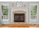Inviting fireplace with decorative mantel and tile surround, flanked by windows that provide natural light at 10607 Newberry Park Ln, Charlotte, NC 28277