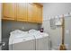 Bright laundry area featuring a side-by-side washer and dryer set, upper cabinets and cleaning supplies storage at 10607 Newberry Park Ln, Charlotte, NC 28277