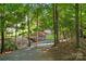 Scenic gravel path with a wooden bridge, surrounded by lush greenery and mature trees, creating a peaceful outdoor retreat at 10607 Newberry Park Ln, Charlotte, NC 28277