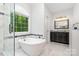 Bathroom featuring a glass shower, free standing soaking tub, and a dark vanity at 10874 Rise Ln, Fort Mill, SC 29707