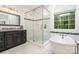 Bathroom featuring a glass shower, free standing soaking tub, and a dark vanity at 10874 Rise Ln, Fort Mill, SC 29707
