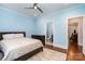 Light blue bedroom with hardwood floors, ceiling fan, and an ensuite bathroom at 10874 Rise Ln, Fort Mill, SC 29707