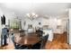 Open dining area with a dark wood table, decorative chandelier, and view to a bright living room at 10874 Rise Ln, Fort Mill, SC 29707