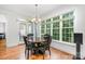 Sunlit dining room with a round wood table and chairs complemented by a large window showcasing lush greenery at 10874 Rise Ln, Fort Mill, SC 29707