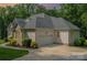 Charming home exterior featuring a gray roof, a two-car garage, and professional landscaping at 10874 Rise Ln, Fort Mill, SC 29707