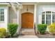 Inviting home entrance with a classic wooden door, brick accents, and neatly trimmed greenery at 10874 Rise Ln, Fort Mill, SC 29707