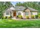 Beautiful home with a manicured lawn, inviting walkway, and lush landscaping at 10874 Rise Ln, Fort Mill, SC 29707