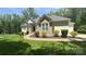 Charming home with manicured lawn, lush landscaping, and a welcoming walkway, all bathed in warm sunlight at 10874 Rise Ln, Fort Mill, SC 29707