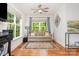 Bright living room features hardwood floors, neutral couch, ceiling fan, and large windows at 10874 Rise Ln, Fort Mill, SC 29707