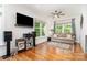 Bright living room features hardwood floors, neutral couch, ceiling fan, and large windows at 10874 Rise Ln, Fort Mill, SC 29707