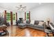 Spacious living room featuring a gray sectional sofa, ceiling fan, and ample natural light from the large windows at 10874 Rise Ln, Fort Mill, SC 29707