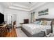 Bright main bedroom with a trey ceiling, hardwood floors, and a view into the ensuite bathroom at 10874 Rise Ln, Fort Mill, SC 29707