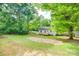 A view of the back of the house with a wooden deck and a large grassy yard at 110 Eighth St, York, SC 29745