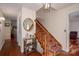 Hallway with wood flooring, stairway with red-patterned carpet, and a round mirror hanging on the wall at 112 Ocean Dr, Shelby, NC 28152