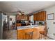 Open kitchen with wood cabinets, tile flooring, breakfast bar, and stainless steel appliances at 112 Ocean Dr, Shelby, NC 28152