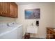 Functional laundry room with washer, dryer, utility sink, and storage cabinets at 112 Ocean Dr, Shelby, NC 28152