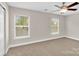 Bright bedroom with neutral carpet, ceiling fan and great natural light from two large windows at 127 Walnut Cove Dr # D, Mooresville, NC 28117
