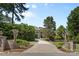 A grand driveway leads to a stately home showcasing manicured landscaping and lush greenery at 1405 Saratoga Woods Dr, Waxhaw, NC 28173