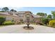 Elegant brick home featuring a grand entryway with a water fountain and lush, manicured landscaping at 1405 Saratoga Woods Dr, Waxhaw, NC 28173
