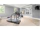 Home gym with treadmill, weight machine, stationary bike, multiple mirrors, and lots of natural light at 1405 Saratoga Woods Dr, Waxhaw, NC 28173