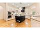 Bright kitchen with stainless steel appliances, granite countertops, a dark center island, and hardwood floors at 1405 Saratoga Woods Dr, Waxhaw, NC 28173