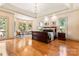 Large primary bedroom boasts hardwood floors, tray ceiling, chandelier, and a bay window sitting area at 1405 Saratoga Woods Dr, Waxhaw, NC 28173