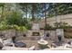 Stone fireplace with seating, offering a cozy outdoor gathering space nestled amongst mature trees at 1405 Saratoga Woods Dr, Waxhaw, NC 28173