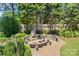 An outdoor kitchen features a built-in grill, ample counter space, and a stone fireplace for an outdoor living space at 1405 Saratoga Woods Dr, Waxhaw, NC 28173